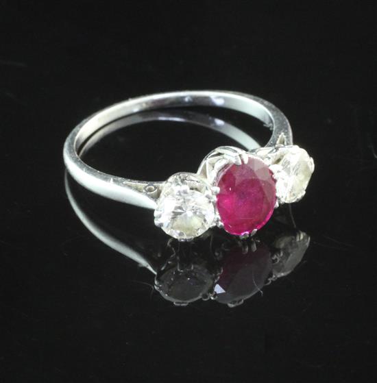 A platinum, ruby and diamond set three stone ring, size M.